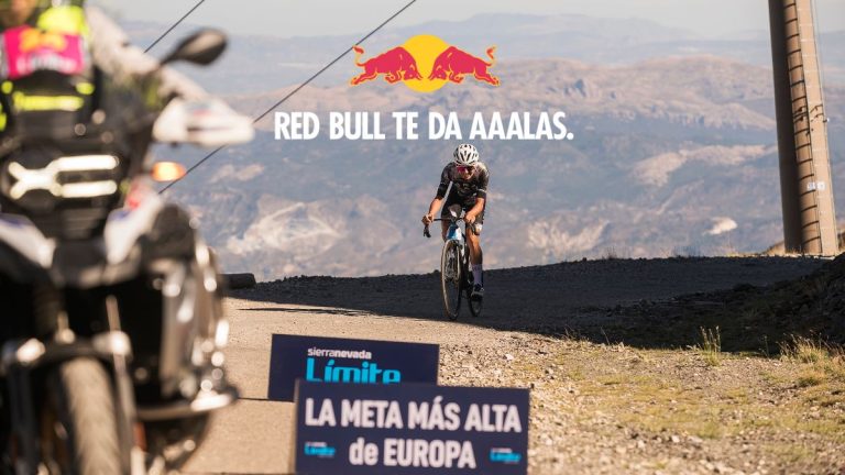 Ciclista coronando la meta de Sierra Nevada Límite, considerada la meta asfaltada más alta de Europa, durante una jornada de ciclismo de alta montaña.